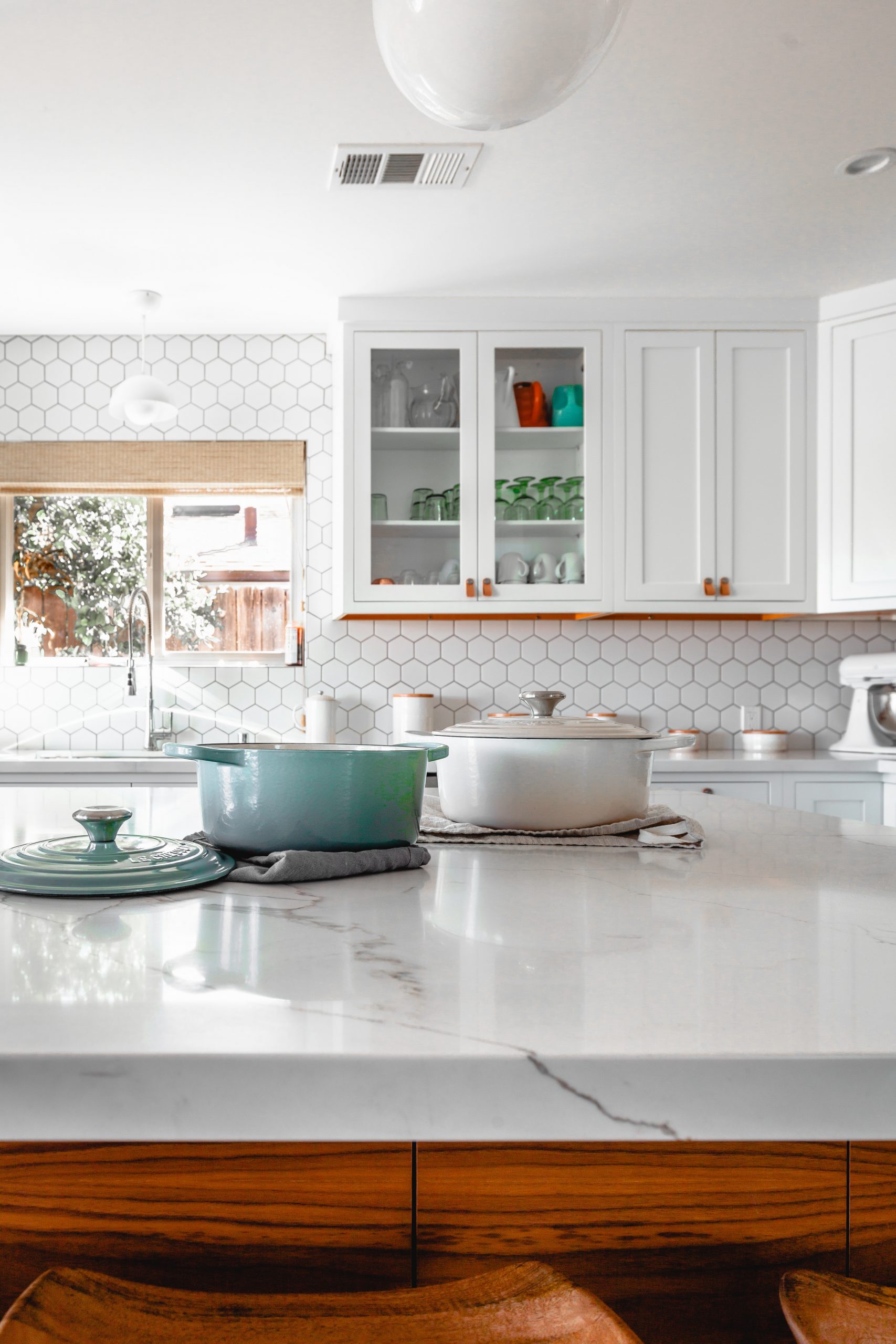 white kitchen like Ramona Aline Home organizer and stylist. aqua and white pots on white quartz island